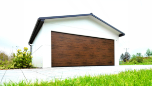 6×5,8m-es delux szigetelt mobilgarázs nyeregtetővel, fehér falakkal, sötét dió szekcionált kapuval és ajtóval, ablakkal, 2db szellőzőráccsal, szegélyekkel, ereszcsatornával, antracitszürke cserepeslemez tetőborítással