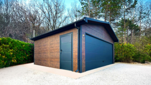 6×5,8m-es delux szigetelt mobilgarázs nyeregtetővel, sötét diófa falakkal, antracitszürke szekcionált kapuval és ajtóval, ablakkal, 2db szellőzőráccsal, szegélyekkel, ereszcsatornával, fekete cserepeslemez tetőborítással