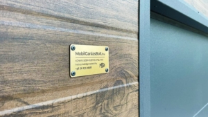 6×5,8m-es delux szigetelt mobilgarázs nyeregtetővel, sötét diófa falakkal, antracitszürke szekcionált kapuval és ajtóval, ablakkal, szellőzőráccsal, szegélyekkel, ereszcsatornával, antracitszürke cserepeslemez tetőborítással