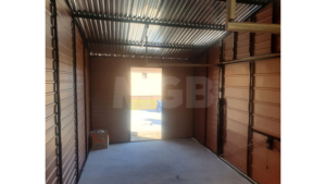 6x3m-es delux fém kerti tároló nyeregtetővel, csokoládébarna cserepeslemez tetővel, világos aranytölgy falakkal, billenőkapuval és ajtóval, ablakkal, ereszcsatornával, szegélyekkel, horganyzott vázszerkezettel, vízszintes lemezborítással