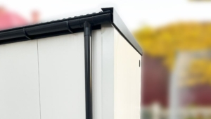 3x5m-es delux szigetelt mobilgarázs antracitszürke nyeregtetővel, fehér falakkal, szekcionált kapuval és ajtóval, szegélyekkel, ereszcsatornával, horganyzott vázszerkezettel