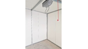 3x5m-es delux szigetelt mobilgarázs antracitszürke nyeregtetővel, fehér falakkal, szekcionált kapuval és ajtóval, szegélyekkel, ereszcsatornával, horganyzott vázszerkezettel