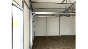 8x6m-es delux szigetelt mobilgarázs, sötét diófa falakkal, nyeregtetővel, antracitszürke szekcionált kapuval és ajtóval, szegélyekkel, ereszcsatonával, horganyzott vázszerkezettel