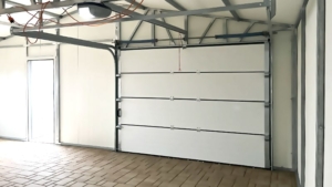 8x6m-es delux szigetelt mobilgarázs, sötét diófa falakkal, nyeregtetővel, antracitszürke szekcionált kapuval és ajtóval, szegélyekkel, ereszcsatonával, horganyzott vázszerkezettel