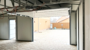 8x6m-es delux szigetelt mobilgarázs, sötét diófa falakkal, nyeregtetővel, antracitszürke szekcionált kapuval és ajtóval, szegélyekkel, ereszcsatonával, horganyzott vázszerkezettel