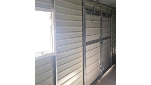 5x3m-es delux tároló jobbra lejtő tetővel, világos aranytölgy falakkal, matt antracitszürke kapuval, ablakkal, ereszcsatornával, szegélyekkel, horganyzott vázszerkezettel, vízszintes lemezborítással