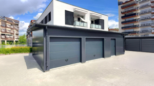 10x6m-es DELUX szigetelt mobilgarázs fordított nyeregtetővel, 2db szekcionált kapuval, 2db ajtóval, ablakkal, 3db szellőzőráccsal, ereszcsatornával, cserepeslemez tetőborítással, horganyzott vázszerkezettel